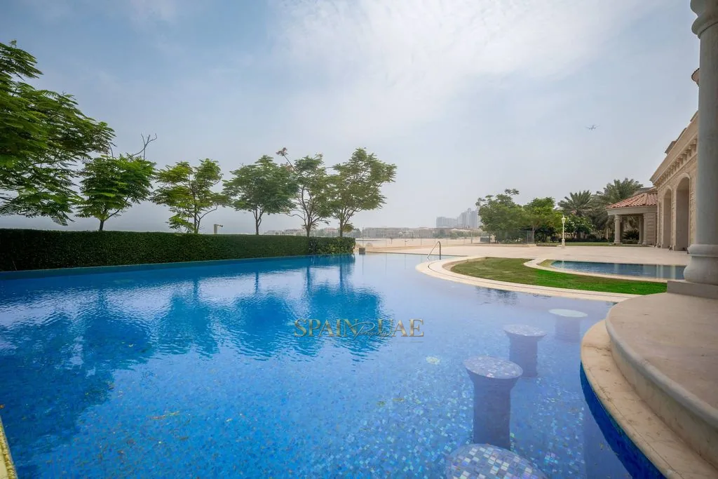 Infinity-edge pool and gardens of The Royal Palace, The Pearl, Doha, with the Arabian Gulf beyond.